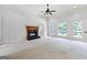 Unfurnished living room featuring a fireplace and natural light from large windows at 230 Hummingbird Ct, Hampton, GA 30228
