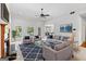 Staged living room with large windows, fireplace, and comfortable seating arrangement at 230 Hummingbird Ct, Hampton, GA 30228
