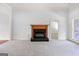 Living room showcasing a fireplace, neutral carpet, and ample natural light at 230 Hummingbird Ct, Hampton, GA 30228