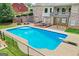 A sparkling in-ground pool with diving board surrounded by brick home and a fenced yard at 230 Hummingbird Ct, Hampton, GA 30228