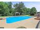 A sparkling backyard pool is surrounded by greenery, patio, and lounge chairs at 230 Hummingbird Ct, Hampton, GA 30228