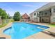 Beautiful backyard pool featuring a dive board, patio seating, and a two-story home at 230 Hummingbird Ct, Hampton, GA 30228