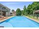 A refreshing in-ground pool surrounded by lush landscaping and a brick home at 230 Hummingbird Ct, Hampton, GA 30228