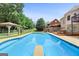 Backyard pool area featuring a dive board, gazebo and outdoor seating with partial home view at 230 Hummingbird Ct, Hampton, GA 30228