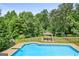 A backyard pool with fenced area, gazebo, and swing set creates a relaxing backyard oasis at 230 Hummingbird Ct, Hampton, GA 30228