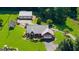 Aerial view of single-story home features a metal roof, attached garage, additional garage, manicured lawn and solar panels at 4335 Hurt Bridge Lane, Cumming, GA 30028