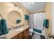 Bathroom showing a neutral toned vanity, round mirror, and a shower with a floral curtain at 4335 Hurt Bridge Lane, Cumming, GA 30028