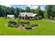 Charming single-story home has a metal roof, attached garage, windmill feature, manicured lawn and solar panels at 4335 Hurt Bridge Lane, Cumming, GA 30028