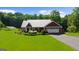 Charming single-story home features a metal roof, an attached garage, manicured lawn and solar panels for energy efficiency at 4335 Hurt Bridge Lane, Cumming, GA 30028