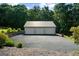 Spacious three-car garage with ample parking space and metal roof, surrounded by lush greenery at 4335 Hurt Bridge Lane, Cumming, GA 30028