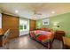 Cozy bedroom with hardwood floors, a colorful quilt, sliding barn doors, and bedside lamps at 4335 Hurt Bridge Lane, Cumming, GA 30028