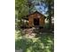 Rustic wooden outbuilding featuring a covered porch, ramp access, and surrounded by lush greenery at 4335 Hurt Bridge Lane, Cumming, GA 30028