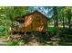 Wooden outbuilding with a ramp and covered porch, surrounded by trees and greenery at 4335 Hurt Bridge Lane, Cumming, GA 30028