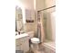 Well-lit bathroom featuring a vanity, toilet, and a shower with a curtain at 241 Balaban Cir # 241, Woodstock, GA 30188
