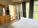 Cozy bedroom featuring a large window, dresser and exterior door leading to a balcony at 241 Balaban Cir # 241, Woodstock, GA 30188