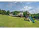 Expansive backyard showcasing a well-maintained lawn, a play structure, and a charming two-story home at 369 Parker Rd, Mcdonough, GA 30252