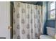 Bathroom featuring shower-tub combo with patterned curtain, toilet, and white door at 369 Parker Rd, Mcdonough, GA 30252