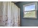 Bathroom featuring a floral shower curtain and window overlooking the trees outside at 369 Parker Rd, Mcdonough, GA 30252