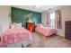 A bedroom with two white iron frame twin beds, green accent wall with flower accents at 369 Parker Rd, Mcdonough, GA 30252