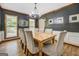 Elegant dining room featuring a large wooden table, matching upholstered chairs, natural light and dark gray walls at 369 Parker Rd, Mcdonough, GA 30252