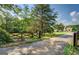 Long driveway leading to a home with a decorative gate and mature trees and landscaping at 369 Parker Rd, Mcdonough, GA 30252