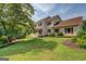 Exterior elevation featuring well maintained lawn and gardens around a 2-story home with red shutters at 369 Parker Rd, Mcdonough, GA 30252