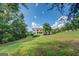 Charming two-story home with red shutters and a sprawling green lawn surrounded by mature trees at 369 Parker Rd, Mcdonough, GA 30252
