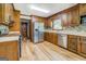 Well-lit kitchen featuring wood cabinetry, stainless steel refrigerator, and stylish tile backsplash, ideal for cooking and entertaining at 369 Parker Rd, Mcdonough, GA 30252