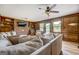 A comfy living room offers a large sectional sofa, wood-like floors, a ceiling fan, and a brick fireplace at 369 Parker Rd, Mcdonough, GA 30252