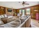 Inviting living room featuring a brick fireplace, wood paneling, wood floors and comfortable seating at 369 Parker Rd, Mcdonough, GA 30252