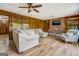Cozy living room with wood paneling, wood floors, brick fireplace, built-in shelves and sectional couch at 369 Parker Rd, Mcdonough, GA 30252