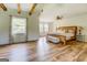 Bright main bedroom with wood floors, exposed beams, and ample natural light from large windows at 369 Parker Rd, Mcdonough, GA 30252