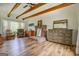 Large main bedroom featuring wood floors, exposed beams, brick fireplace, dresser and sitting area at 369 Parker Rd, Mcdonough, GA 30252