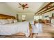 Main bedroom with exposed beams, ensuite bathroom, wood floors, sitting area and a ceiling fan at 369 Parker Rd, Mcdonough, GA 30252