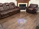 Cozy living room with a brown leather sofa set and a stone fireplace, perfect for relaxation at 8113 Fieldstream Way, Douglasville, GA 30134