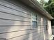 Exterior view of the side of the home, featuring gray horizontal siding and windows at 8113 Fieldstream Way, Douglasville, GA 30134