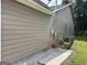 View of the side of the home with horizontal wood siding and concrete pad at 8113 Fieldstream Way, Douglasville, GA 30134