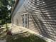 Side of the home showing the wood siding, a patio area, and security door at 8113 Fieldstream Way, Douglasville, GA 30134