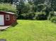 View of backyard features shed, deck, and mature trees at 3155 E Point St, East Point, GA 30344