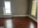 Bright living room with hardwood floors, baseboard trim, and large windows for natural light at 3155 E Point St, East Point, GA 30344