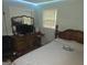 Bedroom with white comforter, wood furniture, and a light above the window at 439 River Rd, Jonesboro, GA 30236