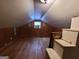 Spacious attic with wood paneled walls and hardwood flooring beneath a sloped ceiling at 1712 Clifton Se Way, Atlanta, GA 30316
