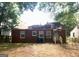 Home's brick exterior with an accessible backyard featuring a lawn and mature trees at 1712 Clifton Se Way, Atlanta, GA 30316