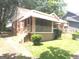 Side view of a charming brick home featuring a screened porch, landscaped yard, and a cozy, welcoming appeal at 1712 Clifton Se Way, Atlanta, GA 30316
