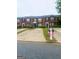 Exterior view of brick townhomes featuring well-maintained landscaping and private driveways at 5553 Strathmoor Manor Cir, Lithonia, GA 30058