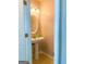 Bright half bathroom featuring a pedestal sink and a decorative oval mirror at 5553 Strathmoor Manor Cir, Lithonia, GA 30058