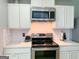 Updated kitchen with white cabinets, stainless steel appliances, and subway tile backsplash at 5553 Strathmoor Manor Cir, Lithonia, GA 30058