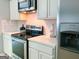 Modern kitchen featuring stainless steel appliances, white cabinetry, and quartz countertops at 5553 Strathmoor Manor Cir, Lithonia, GA 30058