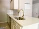 Bright kitchen featuring white quartz countertops, a modern faucet and stylish backsplash at 5553 Strathmoor Manor Cir, Lithonia, GA 30058