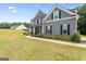 Well-maintained home with gray siding, black shutters, and a sidewalk leading to the front door at 935 S Laney Rd, Locust Grove, GA 30248